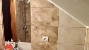 Un baño con lavamanos, inodoro y ducha.