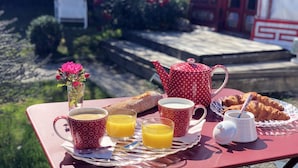 A breakfast table with croissants, orange juice, and a teapot. - Yourte au Paradis (Souvigné)