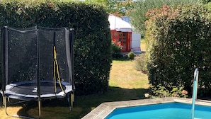 A backyard with a trampoline and a swimming pool. - Yourte au Paradis (Souvigné)
