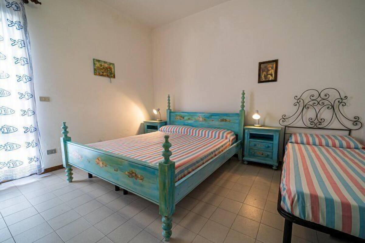 Une chambre à coucher avec un lit, deux tables de chevet et une commode.