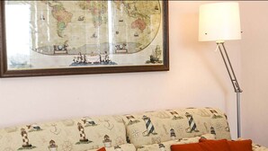 Een kamer met een bank, een lamp en een inlijsting kaart aan de muur.