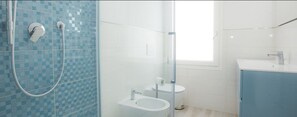 A bathroom with a shower, toilet, and sink.
