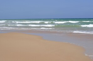 Rannalla, aurinkotuoleja, rantapyyhkeitä