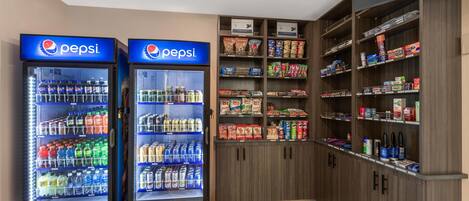 Two Pepsi vending machines and a variety of snacks and beverages in a store.