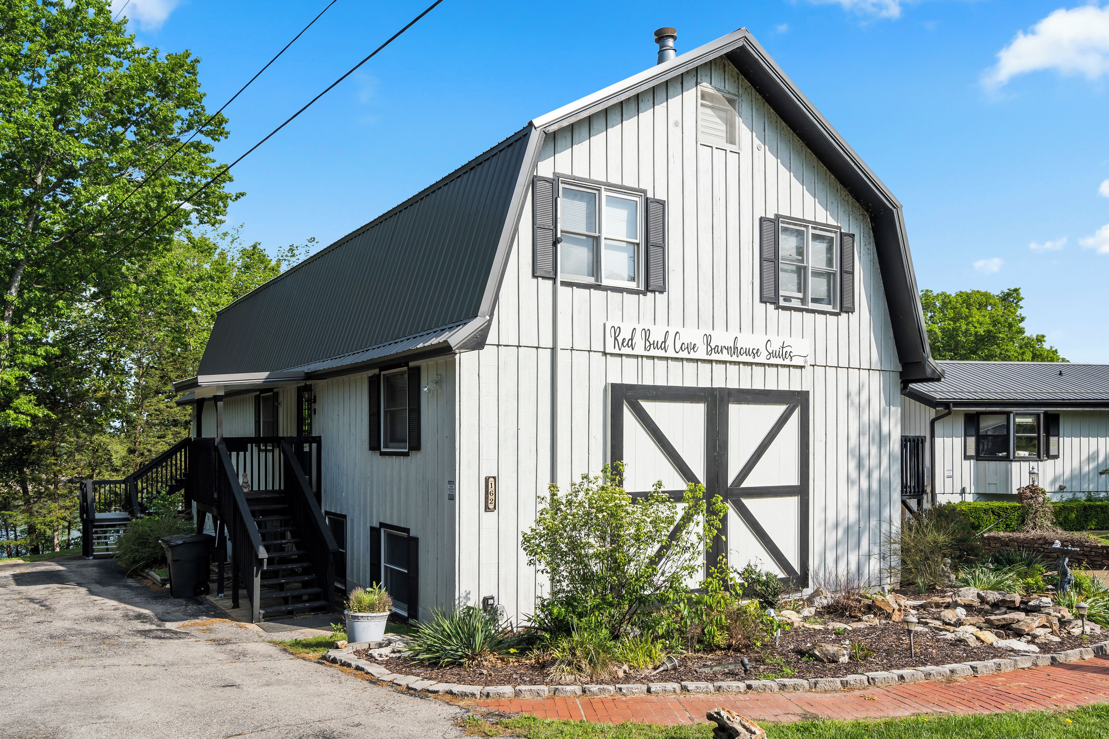 Un edificio bianco con un cartello che recita 'Red Bud Cove Barnhouse Suites'.