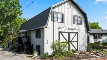 Un edificio bianco con un cartello che recita 'Red Bud Cove Barnhouse Suites'.