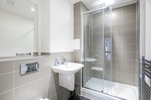 Appartement (First Floor) | Badkamer | Een bad/douchecombinatie, een haardroger, handdoeken, zeep