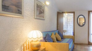 A cozy room with a bed, a lamp, and two framed pictures on the wall. - Mansarda il Sarago (Campo nell'Elba)