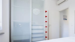 Un dormitorio con cama, armario y puerta.