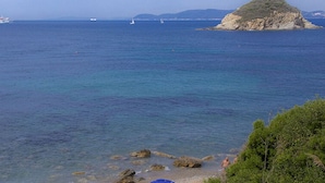 A coastal view with clear water, a boat, and rocky terrain. - Punta dei Barbari (Rio)