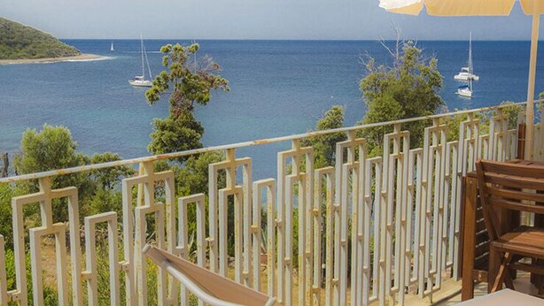 A balcony with a view of the sea, wooden chairs, and a white fence. - Punta dei Barbari (Rio)