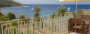 A balcony with a view of the sea, wooden chairs, and a white fence. - Punta dei Barbari (Rio)
