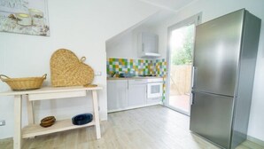 Eine moderne Küche mit einem Edelstahlkühlschrank, einem weißen Schrank und einer farbenfrohen Spritzschutzwand.