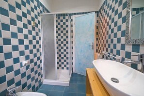 A bathroom with a shower, a sink, and a mirror.