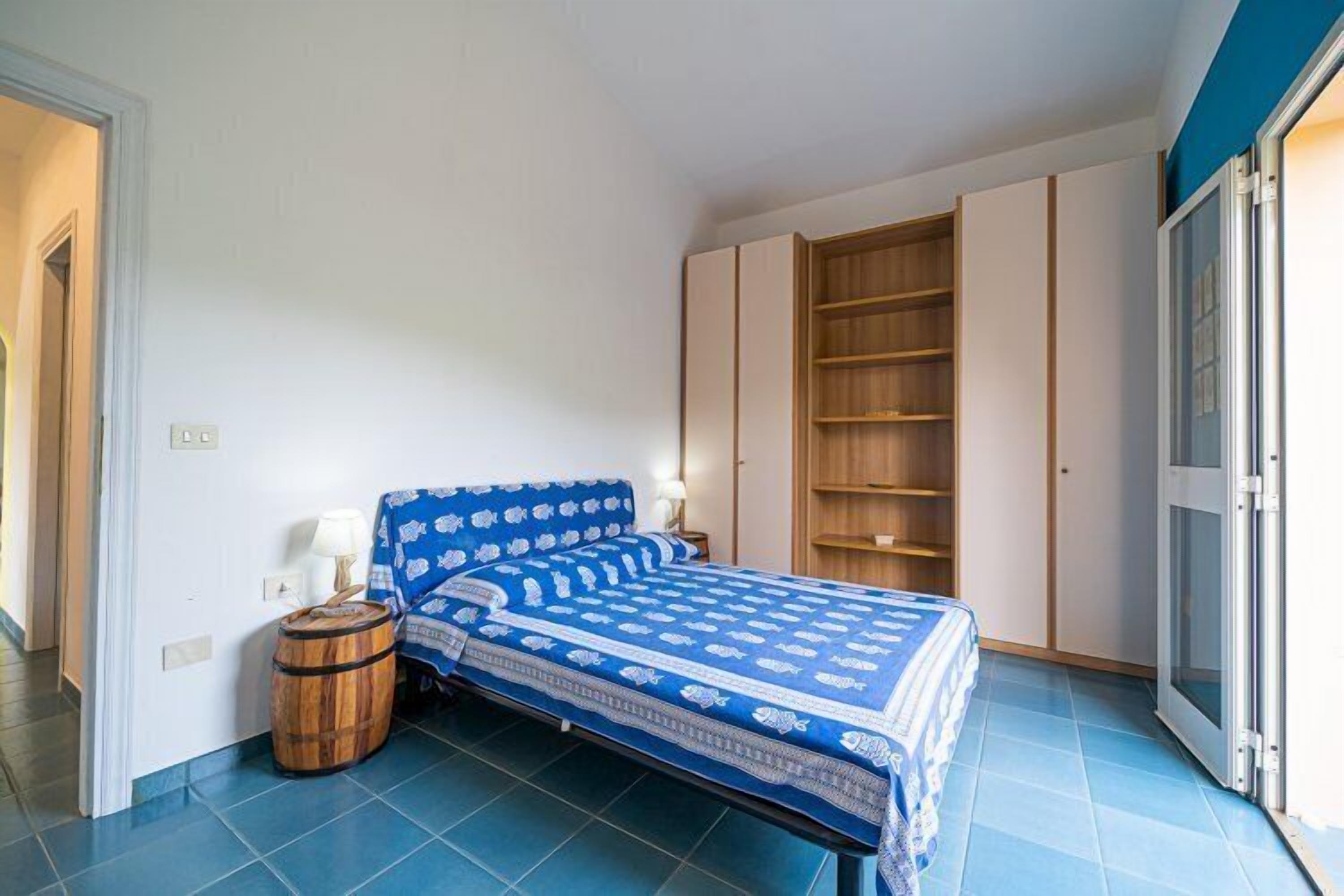 Ein Schlafzimmer mit einem Bett, einem Holzbottich, einem Kleiderschrank und einer Schiebetür.