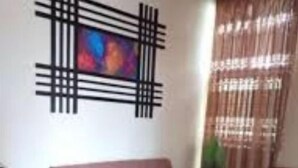 Un salon avec un canapé, une table basse et un téléviseur fixé au mur.