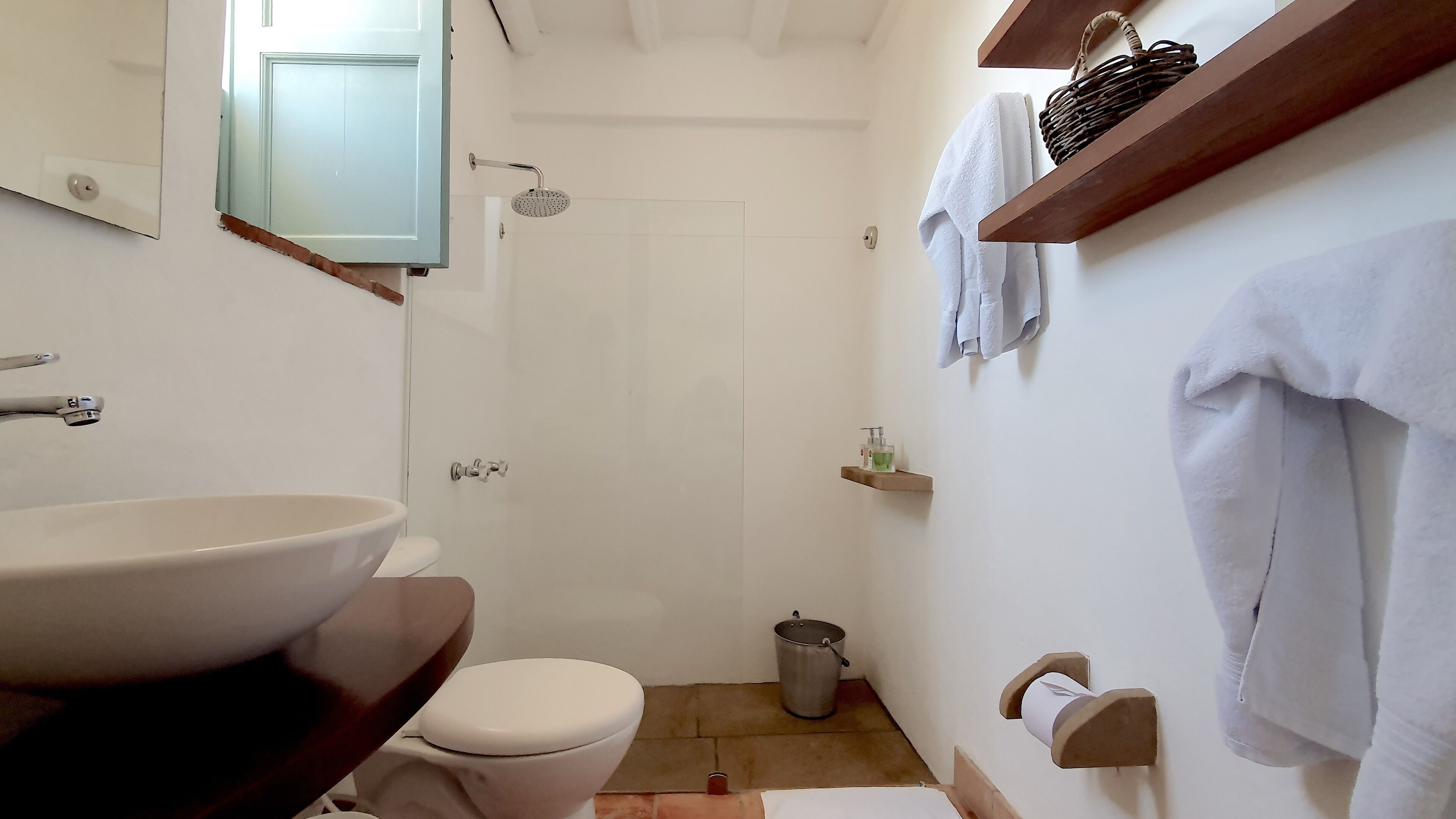 A bathroom with a sink, toilet, shower, and a towel rack.