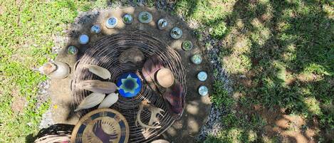 Disposición circular de varios objetos decorativos, entre ellos una cesta tejida, un plato azul y varios platos con diferentes diseños.