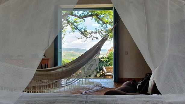 Una hamaca en una habitación con vista a un paisaje a través de una ventana.