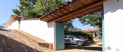 Un edificio con techo de tejas, una escalera y un coche estacionado.