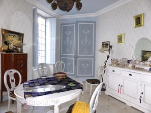 A dining area with a round table, chairs, and a white cabinet with drawers. - - The Villa Premayac - (Blaye)
