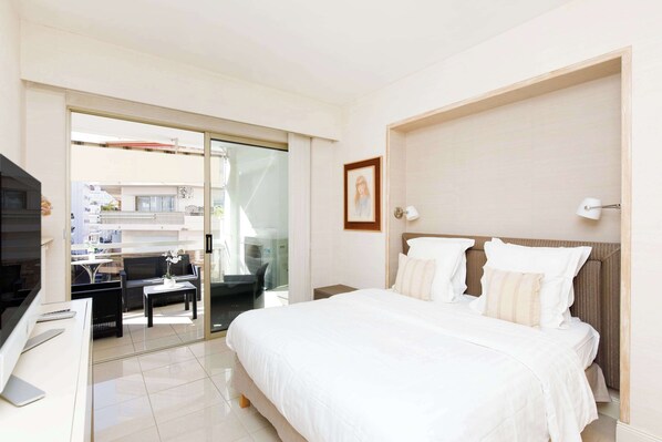 A hotel room with a bed, a desk, and a view of the outside. - Martinez hotel area: 2 beds/2 baths (Cannes)