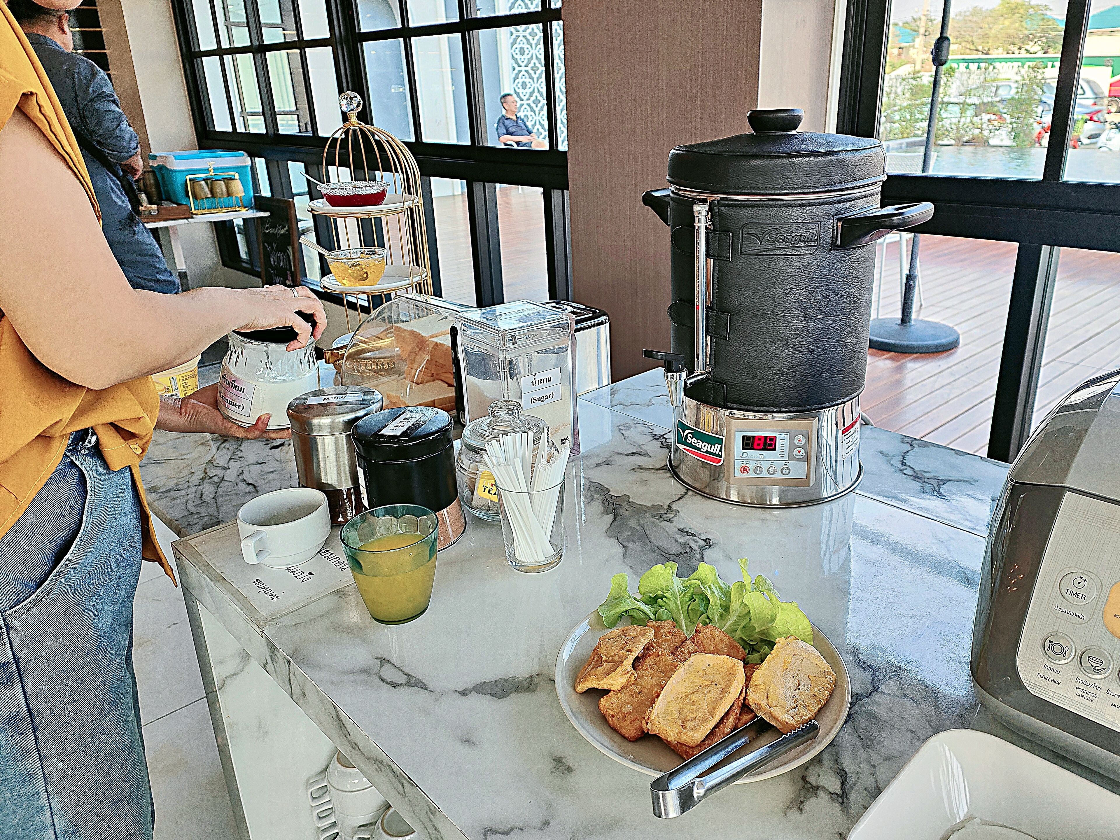 Eine Küchenarbeitsfläche mit Kaffeemaschine, einem Topf und einer Teller mit Essen.