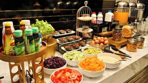 A buffet with various food items and condiments. - Koco Hotel (Nakhon Ratchasima)