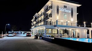A multi-story hotel with balconies, a pool, and a well-lit exterior. - Koco Hotel (Nakhon Ratchasima)
