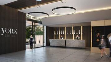 A modern hotel lobby with a reception desk, a large sign for 'YORK SUITES', and a clean, contemporary design.