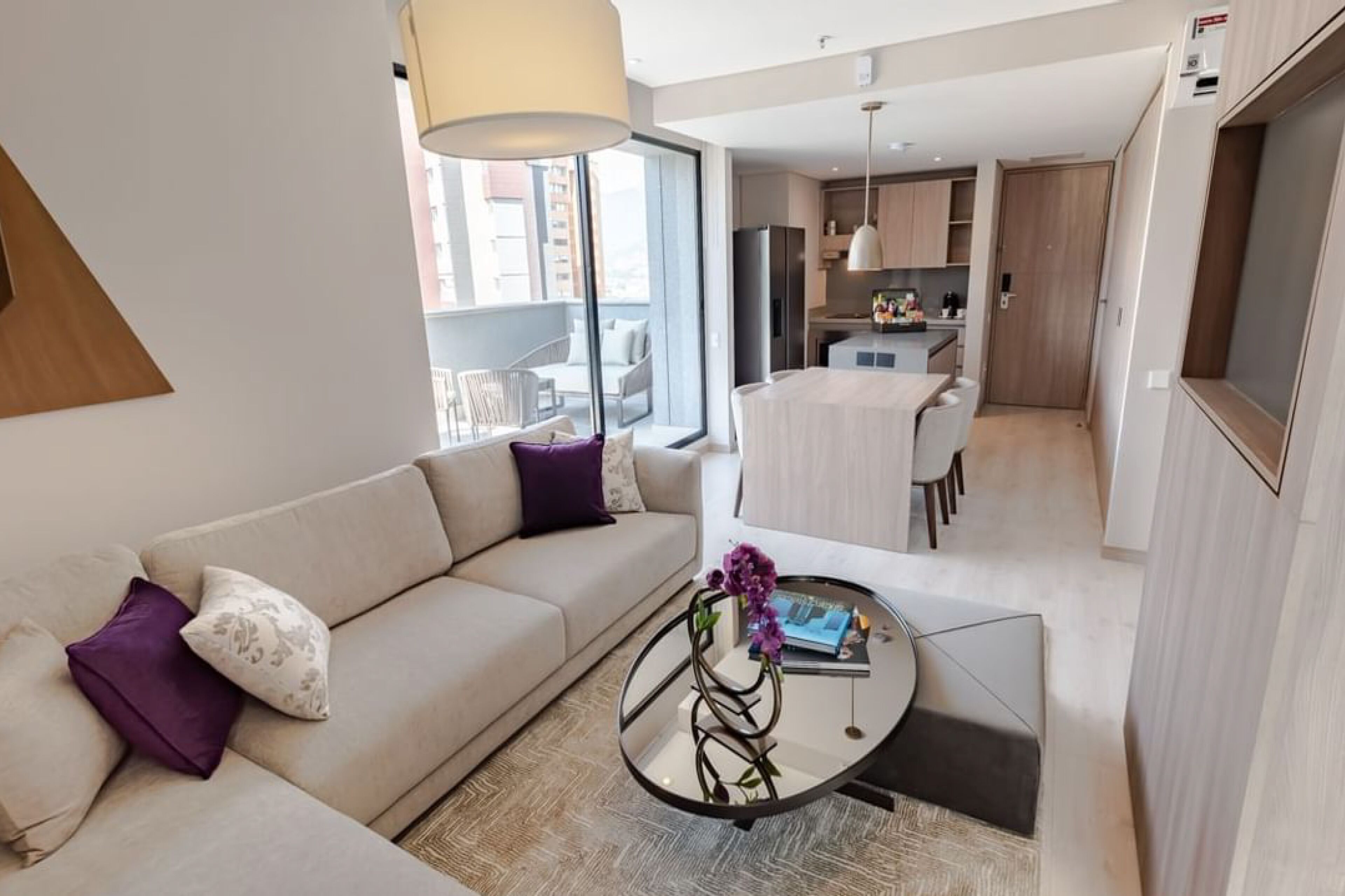 Una sala de estar moderna con un sofá, una mesa de centro y vistas al balcón.