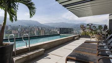 Una piscina cubierta, una piscina al aire libre, tumbonas