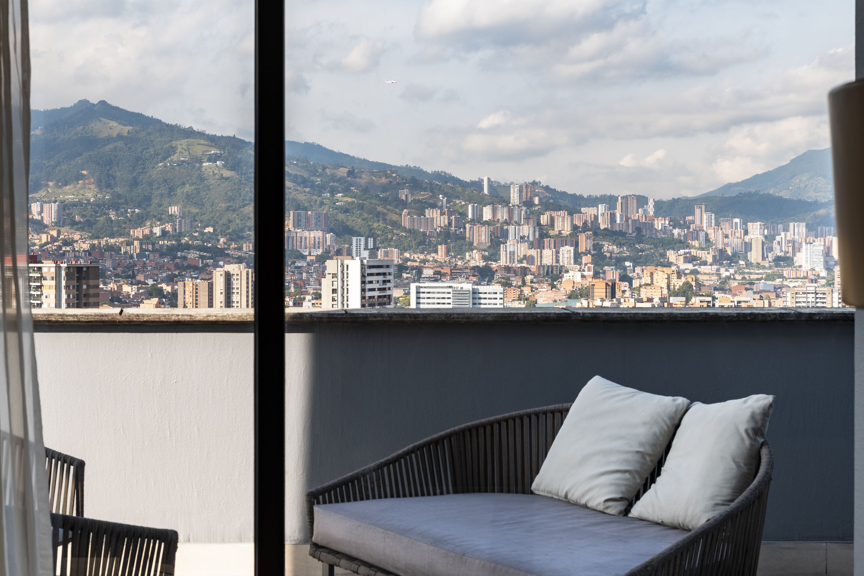 A balcony with a view of a cityscape and mountains.