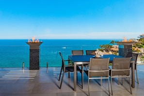 An outdoor dining area with a table and chairs, overlooking a body of water. - Villa in Cabo San Lucas 1034 (Cabo San Lucas)