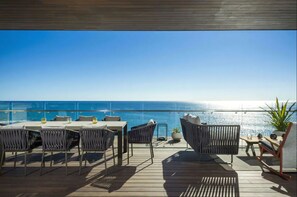 Una terraza con asientos al aire libre, una mesa y una planta en maceta.