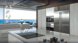 A modern kitchen with a large island, stainless steel appliances, and a view of the ocean. - Luxury Holiday Penthouse With Majestic Ocean Views, Cabo San Lucas Penthouse 1024 (San José del Cabo)