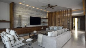 A modern living room with a large flat-screen TV, a sofa, a coffee table, and a decorative wall. - Luxury Holiday Penthouse With Majestic Ocean Views, Cabo San Lucas Penthouse 1024 (San José del Cabo)