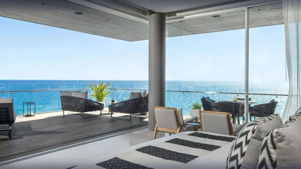 A modern balcony with a view of the ocean, furnished with sofas and chairs, and a dining area with a table and chairs. - Luxury Holiday Penthouse With Majestic Ocean Views, Cabo San Lucas Penthouse 1024 (San José del Cabo)