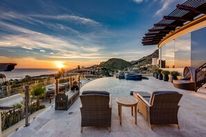 A rooftop terrace with wicker furniture, a pool, and a view of the sunset over the ocean. - The Ultimate Holiday Villa in Cabo San Lucas With Private Pool and Close to the Beach, Cabo San Lucas Villa 1011 (Cabo San Lucas)