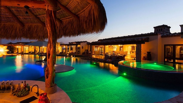 A luxurious pool area with a thatched roof structure, multiple lounge areas, and a well-lit interior. - Beautiful Holiday Villa in a Prime Location in Cabo San Lucas 1007 (Cabo San Lucas)