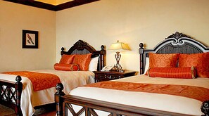 Una habitación de hotel con dos camas dobles, cabeceros de madera y ropa de cama roja a juego.