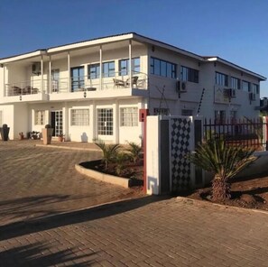 Stunning two-story building with a central entrance and double doors, flanked by windows, and a small balcony above.