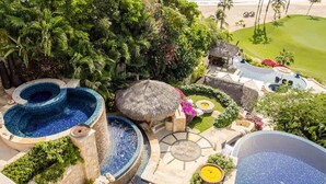 A luxurious resort with multiple swimming pools, a thatched-roof structure, and a view of the beach. - The Ultimate Holiday Villa in San José del Cabo With Private Pool and Close to the Beach, San Jose Del Cabo Villa 1008 (San José del Cabo)