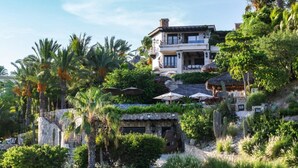 A large, two-story house with a balcony, surrounded by lush greenery and palm trees. - The Ultimate Holiday Villa in San José del Cabo With Private Pool and Close to the Beach, San Jose Del Cabo Villa 1008 (San José del Cabo)