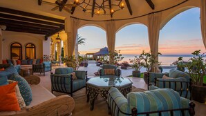 A luxurious outdoor lounge area with seating, a view of the ocean, and a sunset. - Luxury Holiday Villa near Main Attractions, San Jose del Cabo Villa 1019 (San José del Cabo)