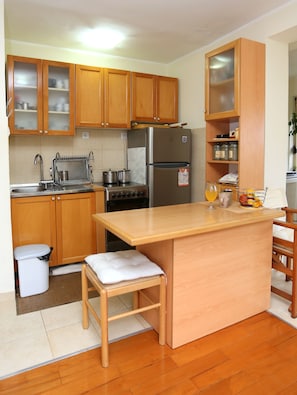 Enjoy cooking in this kitchen with an oven, stainless steel refrigerator, and sink with faucet.