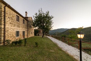 A stone building with a gravel path and a wooden fence.