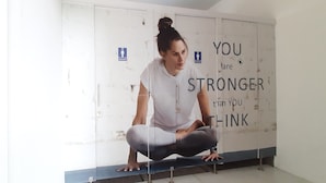 Eine Person sitzt auf einer Bank in einem Raum, dessen Wand motivierende Worte zeigt.
