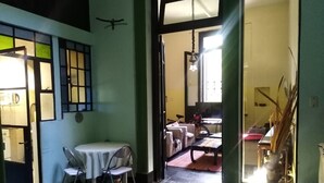 A room with a dining table and chairs, a sofa, and a bicycle in the background. - FABULOSO BUENOS AIRES  ONE (Ground floor Balvanera)
