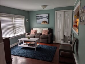Un salon avec un canapé, une table basse et une porte.
